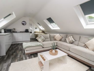 A living room with a sofa and kitchen area at Fields view in Bridlington