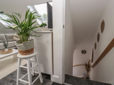 A staircase with a plant and stool at Fields View in Fraisthorpe