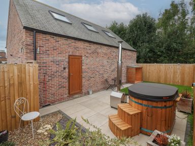 A garden with a hot tub and seating area at Fields View in Fraisthorpe