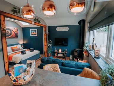 A living room with a bed, sofa, and television at TyCosy in St Davids