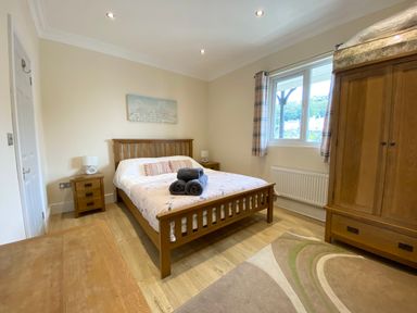 A bedroom with a bed and wardrobe at Rivercrest in Looe
