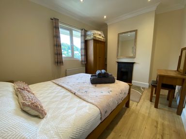 A bedroom with a bed and wardrobe at Rivercrest in Looe
