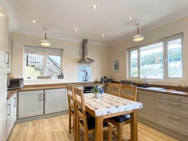 A kitchen with a table and chairs at Rivercrest in Looe