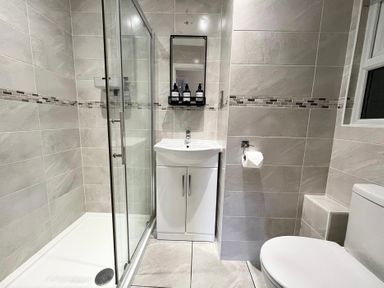 A bathroom with a shower, sink, and toilet at Rivercrest in Looe