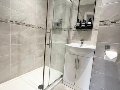 A bathroom with a shower and sink at Rivercrest in Looe