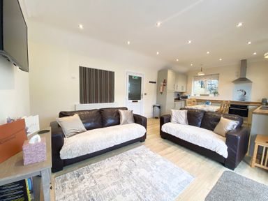 A living room with two sofas and a dining area at Rivercrest in Looe