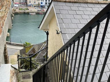 A view of stairs leading down to a waterfront area at Rivercrest in Looe