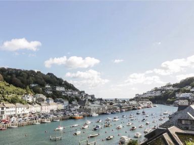 A view of a harbor with boats and houses at Rivercrest in Looe