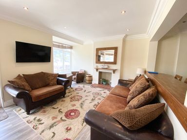 A living room with a sofa and armchairs at Nesden House 