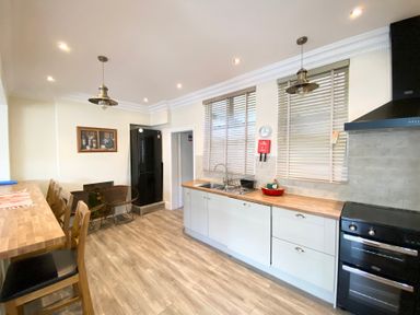 A kitchen with a refrigerator and sink at Nesden House 