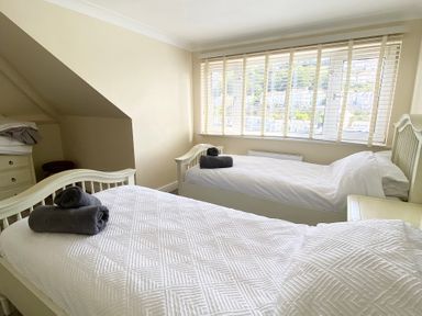 A bedroom with two beds and a dresser at Nesden House