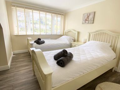 A bedroom with two beds and a window at Nesden House