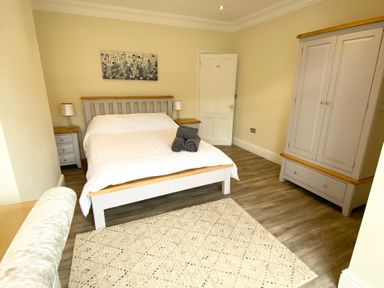 A bedroom with a bed and wardrobe at Nesden House
