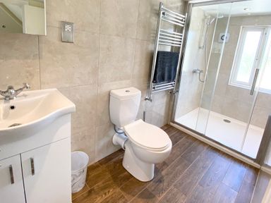 A bathroom with a toilet, sink, and shower at Nesden House in 
