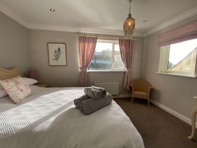 A bedroom with a bed and window at Harbour Lodge in Looe