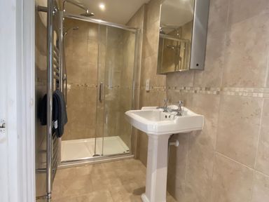A bathroom with a shower and sink at Harbour Lodge in Looe
