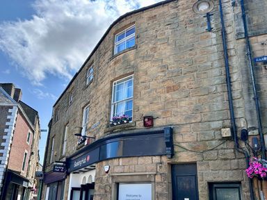 A building exterior with windows and a sign at Banking Hub in Alnwick