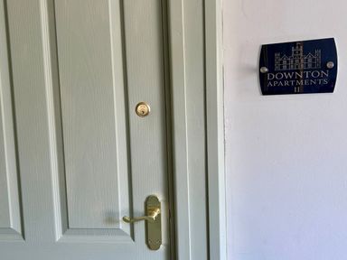 A door with a nameplate indicating Downton Apartments II in Alnwick