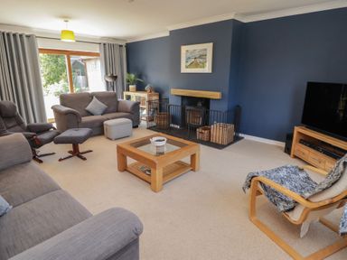A living room with a sofa and chairs at Ty Traeth in Porthcawl