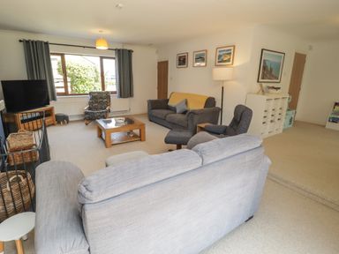 A living room with a sofa and television at Ty Traeth in Porthcawl