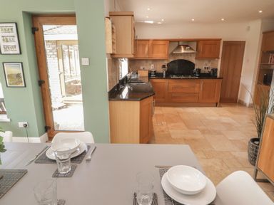 A kitchen with a table and chairs at Ty Traeth in Porthcawl