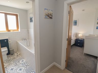 A bathroom with tub and toilet at Ty Traeth in Porthcawl