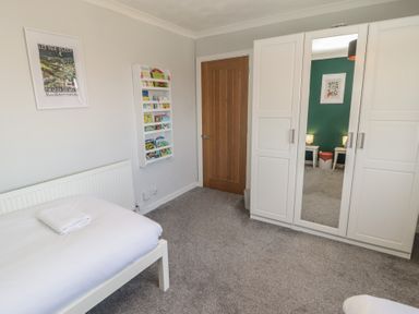 A bedroom with a bed and wardrobe at Ty Traeth in Porthcawl