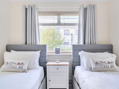 A bedroom with two beds and a bedside table at Sleeps 9 KingBeds Family Friendly in Pityme near Penmayne