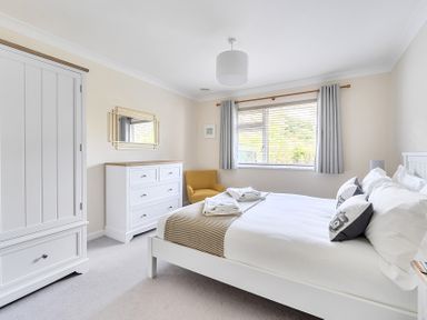 A bedroom with a bed and dresser at Sleeps 9 KingBeds Family Friendly in Pityme near Penmayne