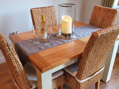 A dining table with a wine bottle and glasses at Stunning 2 Bedroom Pet Friendly Lodge in Bridlington