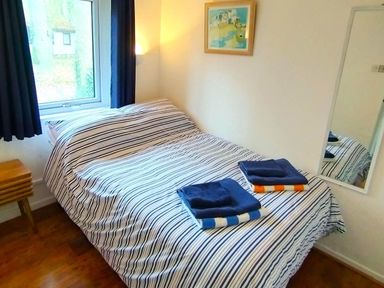 A bedroom with a bed and towels at Painters Cottage 2Bed Chalet Free Leisure Passes Near St Ives