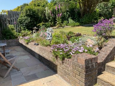 A garden with flowers and a statue at Bungalow Sleeps 2 Parking in Newquay