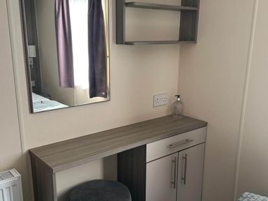 A bedroom with a mirror and a small desk at Caravan in Holcot Sleeps 6 Max 6 people Max 4 adults per booking Pet Friendly Holcot near Moulton