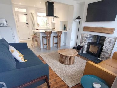 A living room with a sofa and coffee table at Looe Cottage Seaside views log fire sleeps 4 in Looe
