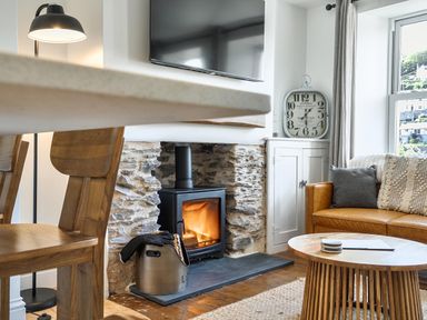 A living room with a wood stove and television at Looe Cottage Seaside views log fire sleeps 4 in Looe