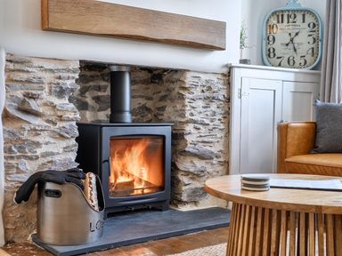 A living room with a wood stove and coffee table at Looe Cottage Seaside views log fire sleeps 4 in Looe