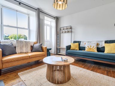 A living room with two sofas and a coffee table at Looe Cottage Seaside views log fire sleeps 4 Looe