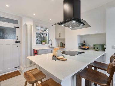 A kitchen with countertop and stools at Looe Cottage Seaside views log fire sleeps 4 in Looe