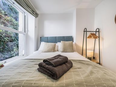 A bedroom with a bed and clothing rack at Looe Cottage Seaside views log fire sleeps 4 in Looe