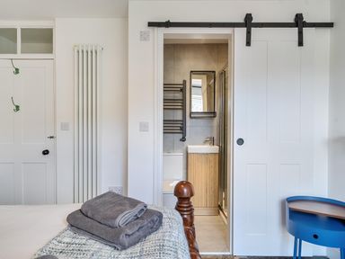 A bedroom with a view into the bathroom at Looe Cottage Seaside views log fire sleeps 4 Looe