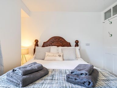 A bedroom with a bed and bedside lamp at Looe Cottage Seaside views log fire sleeps 4 in Looe