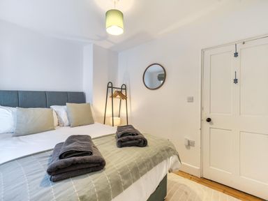 A bedroom with a bed and coat rack at Looe Cottage Seaside views log fire sleeps 4 in Looe