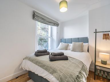 A bedroom with a bed and bedside table at Looe Cottage Seaside views log fire sleeps 4 in Looe