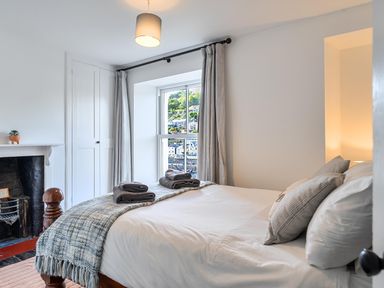 A bedroom with a bed and window at Looe Cottage Seaside views log fire sleeps 4, Looe