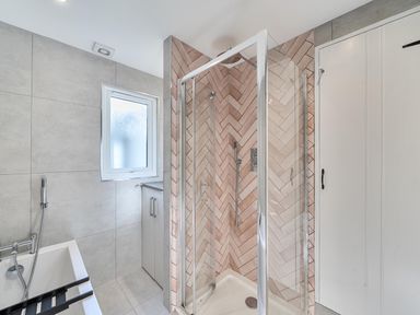 A bathroom with a shower and bathtub at Looe Cottage Seaside views log fire sleeps 4 in Looe