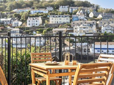 An outdoor seating area with a table and chairs at Looe Cottage Seaside views log fire sleeps 4 in Looe