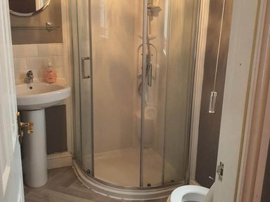 A bathroom with a shower, wash basin, and toilet at 