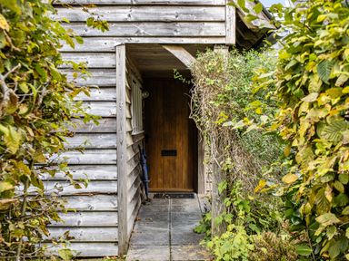 A wooden door with a stone pathway at Cabin Sleeps 6 with Parking and Patio, Tremail near Camelford