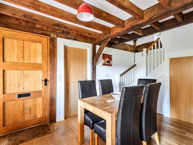 A dining room with a wooden table and chairs at Cabin Sleeps 6 with Parking and Patio in Tremail near Camelford