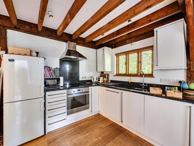 A kitchen with appliances and wooden beams at Cabin Sleeps 6 with Parking and Patio in Tremail near Camelford